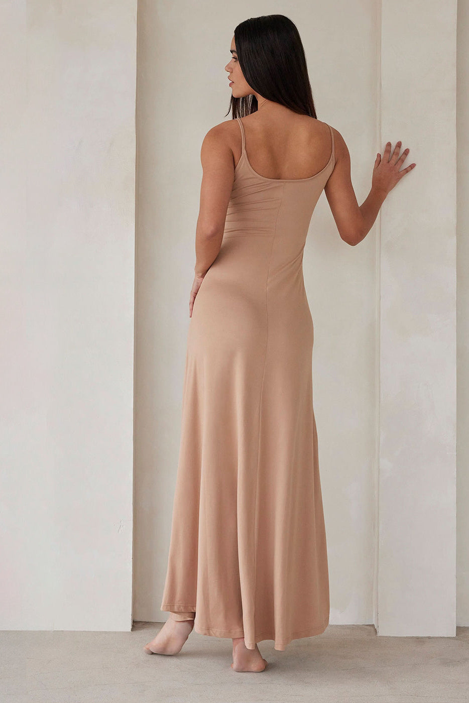 Back view of the oat maternity Cloud Maxi Dress showcasing thin stretchy straps and a floor-length relaxed fit indoors