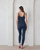 Back view of a pregnant woman in a navy jumpsuit by Bumpsuit